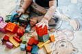 Baby playing with silicone blocks and wooden toys.