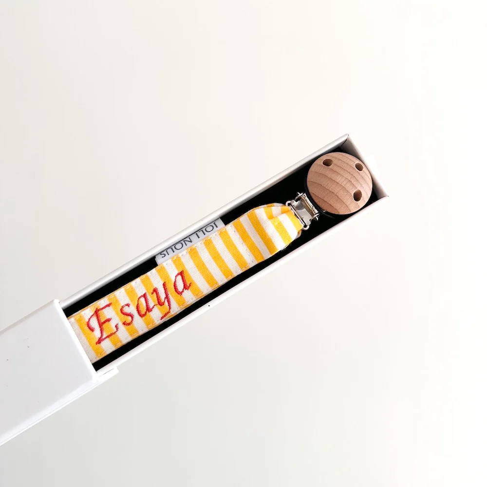 Attache-tétine fraises rouge blanc élégant de la marque suisse 'Joli Nous', un accessoire premium pour bébé, alliant design raffiné et qualité exceptionnelle