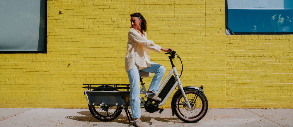 Woman sitting on Specialized Globe Haul electric bike on sidewalk