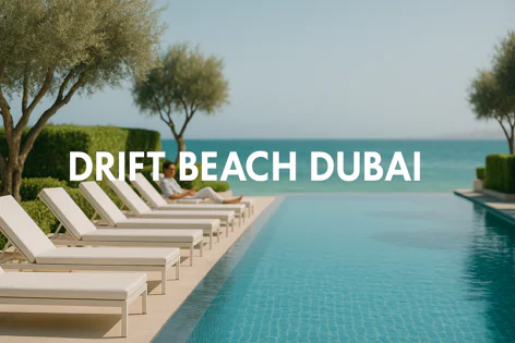 Man relaxing on a sun lounger next to an infinity pool at Drift Beach Dubai, overlooking the sea with trees nearby.