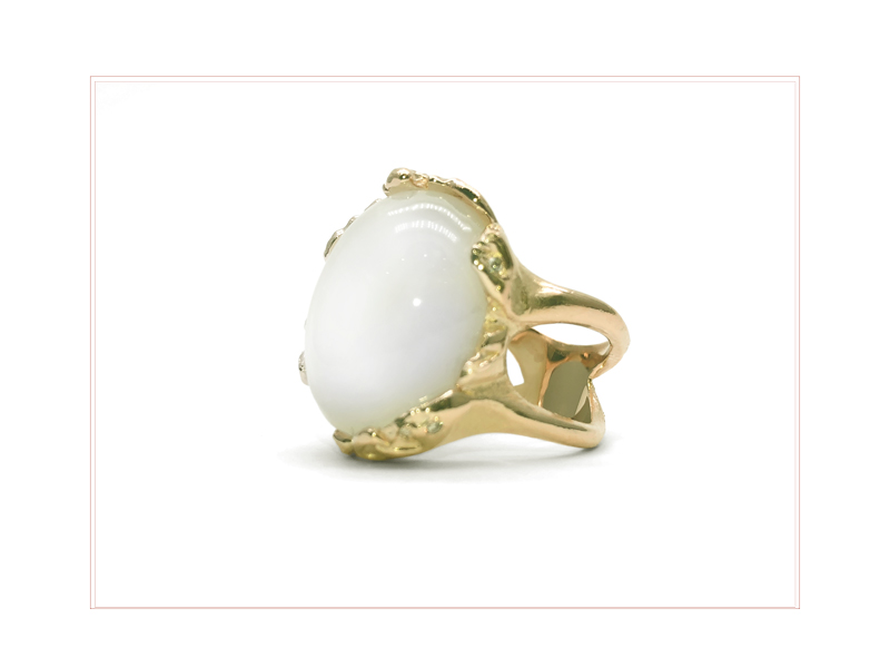 Large quartz stone mounted on a ring with irregular yellow gold rings