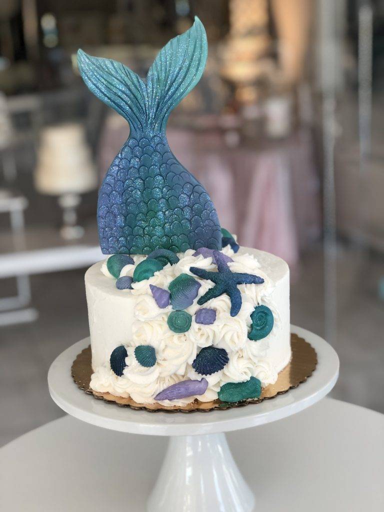 Mermaid themed birthday cake with a blue and purple mermaid tail and shell details.