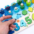 A man's fingers holding a blue wooden piece of the Montessori Smart Board educational toy, with the wooden board beneath it.