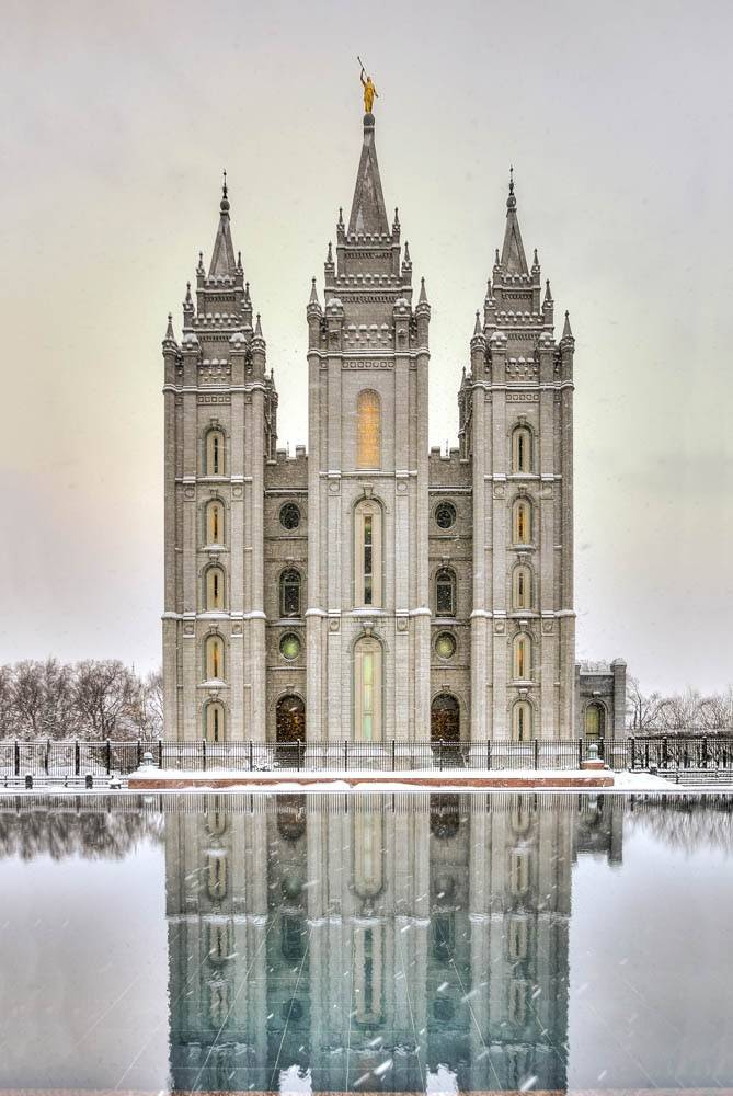 Salt Lake Temple and snowfall reflected in reflection pool.