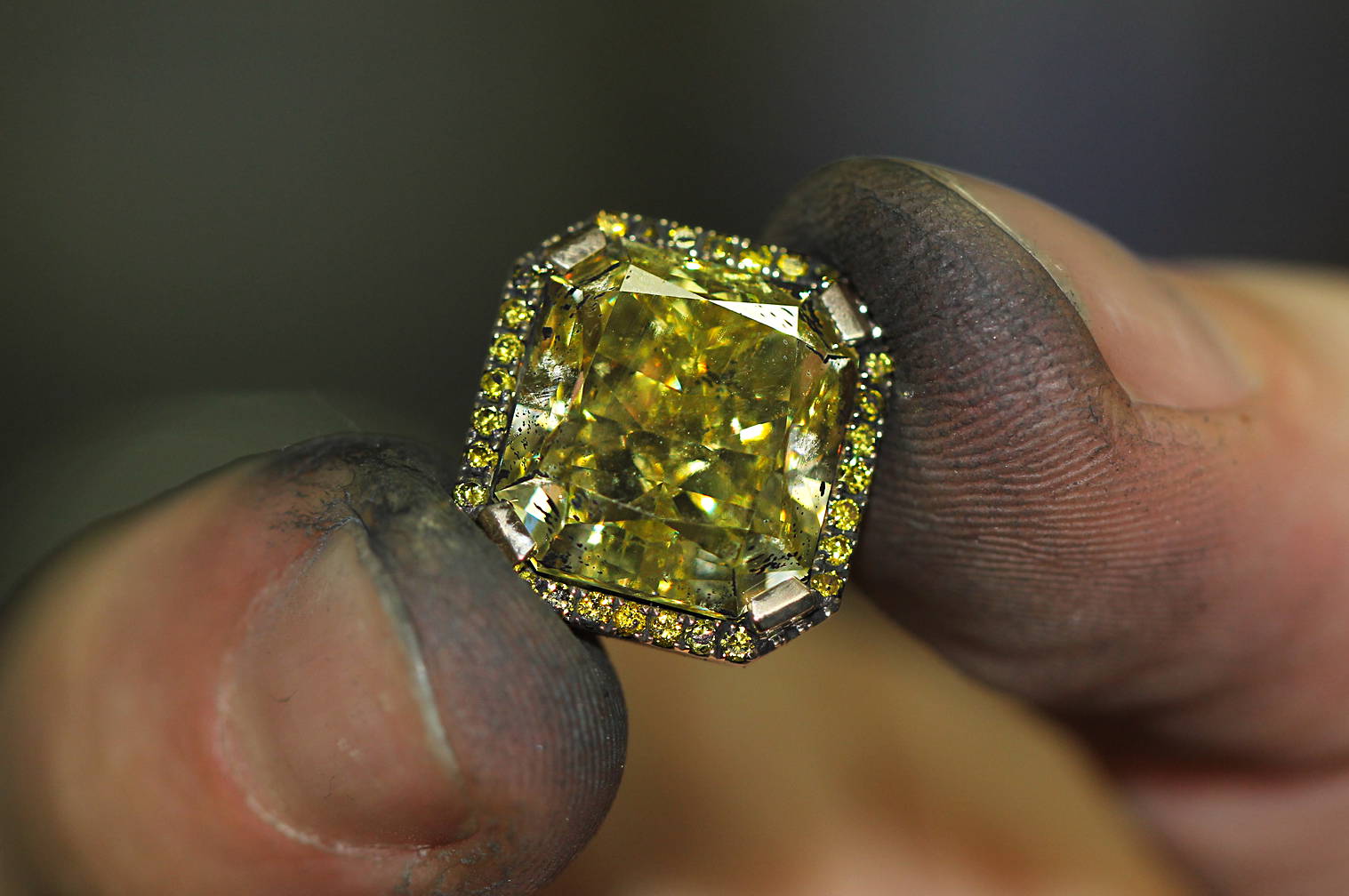diamond in the fingers of a jewelry master yves lemay jewelry