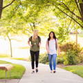 blonde_and_brunette_female_college_students_walking_across_campus blonde_and_brunette_female_college_students_walking_across_campus