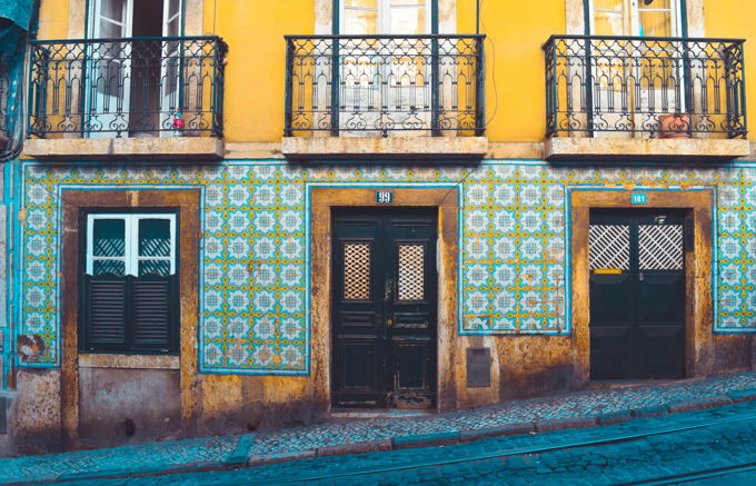 Street photo with a building with windows, balconies, and doors
