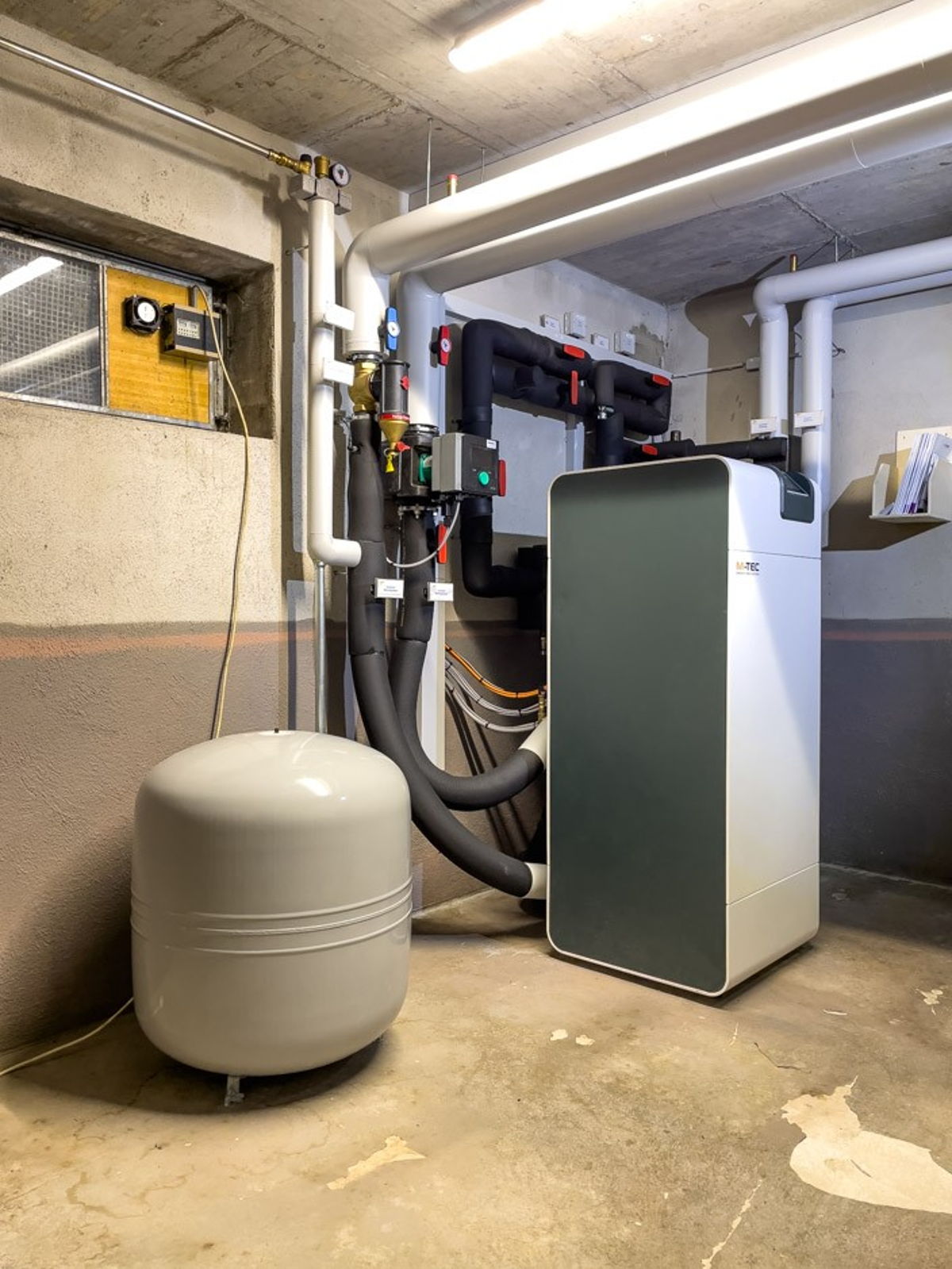 Foto Kundenreferenz Mehrfamilienhaus Altbau Technikraum Wärmepumpe Grundwasser