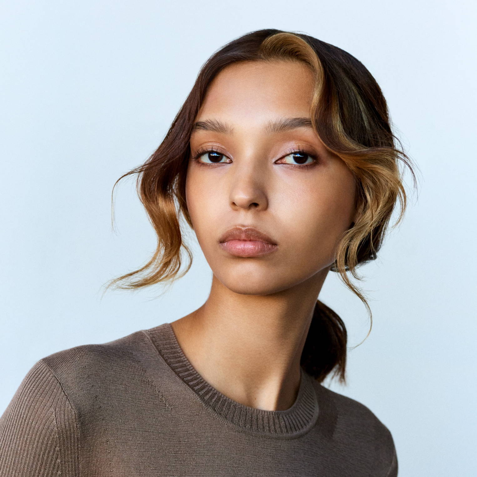Davines hair model with a textured, messy ponytail