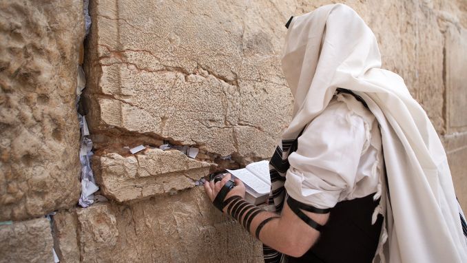 Jewish man praying at the Western wall in Jerusalem
