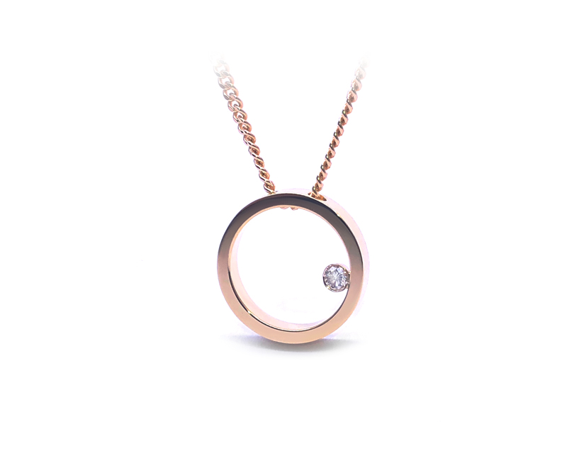 round pendant in yellow gold with small diamond inside