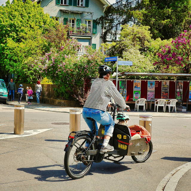 Mom riding bakfiets cargo bike with child