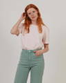 Woman wearing light pink organic cotton t-shirt with sage green organic cotton high waisted trousers from British sustainable clothing brand Goose Studios.