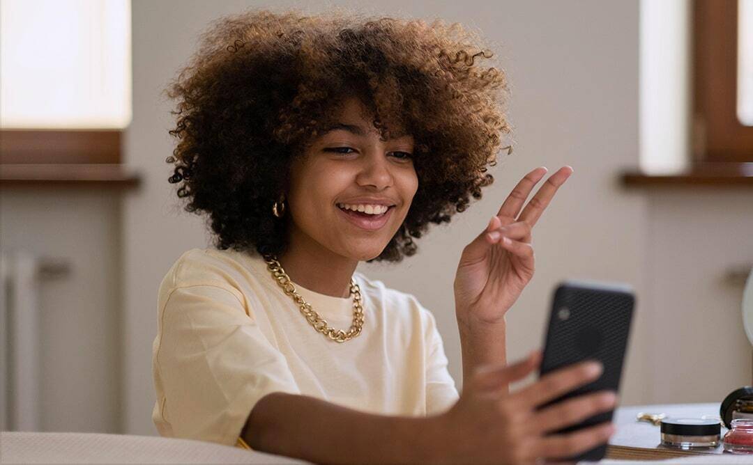 Criadora de conteúdo sorrindo enquanto grava vídeo