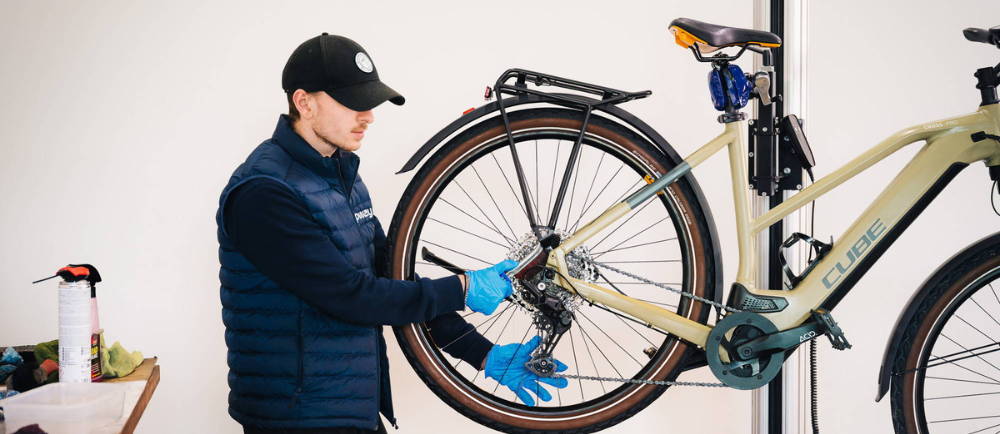 Upway mechanic repairing Cube electric mountain bike in stand