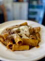 a bowl of paccheri pasta with meat sauce