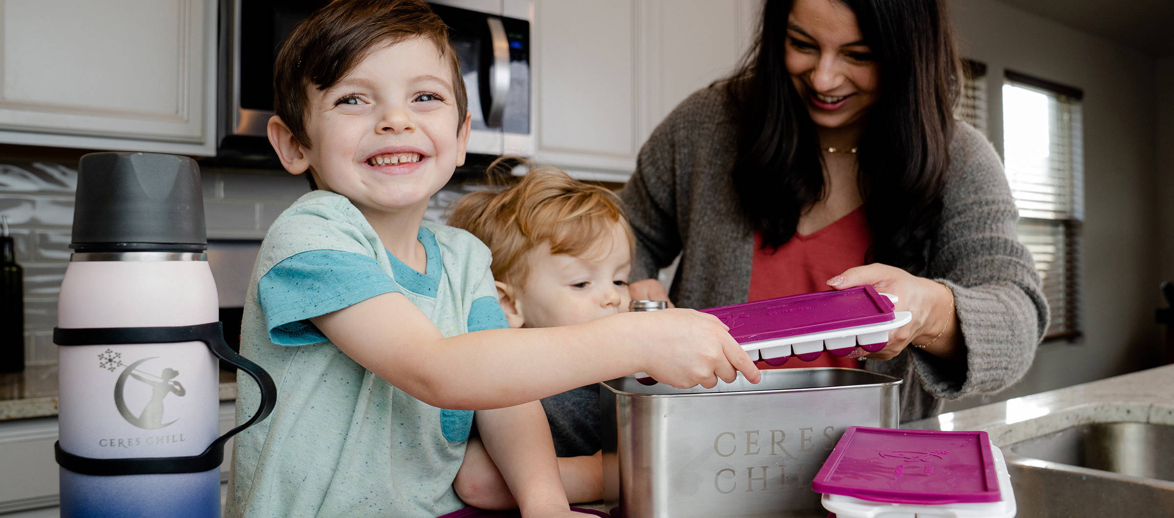 A busy family with young children makes fun work of warming up cubes of milk for the new baby.