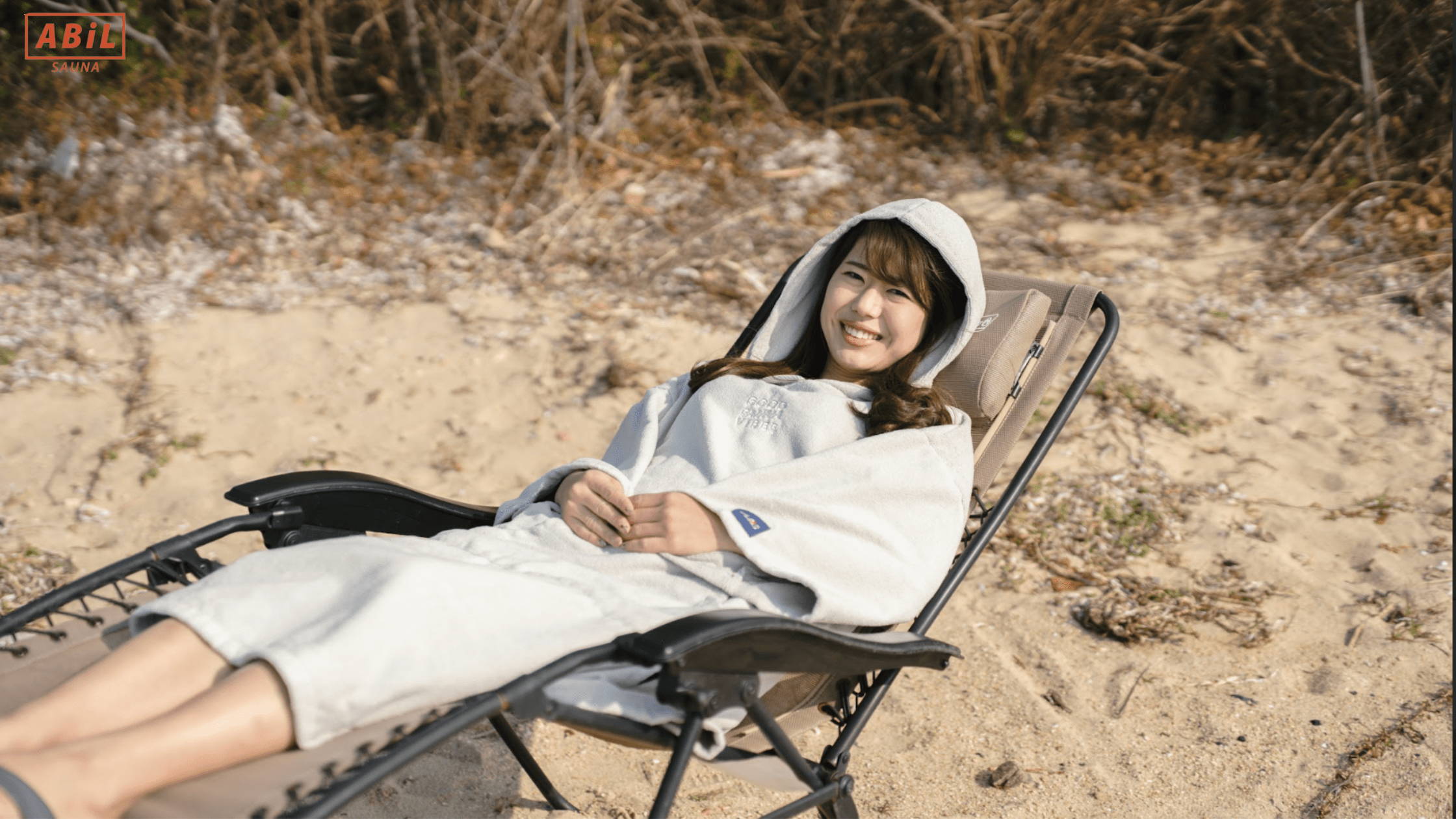 ABiLサウナポンチョを着て外気浴を楽しむ女性の様子