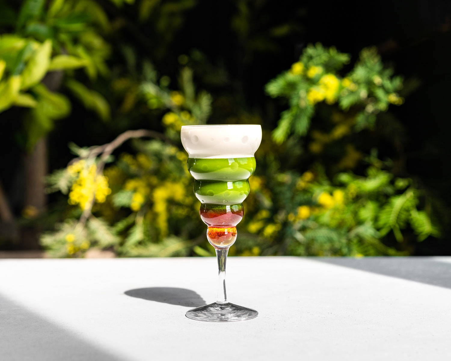 A vivid strawberry matcha latte beautifully displayed in a tiered glass, by SingleThread.