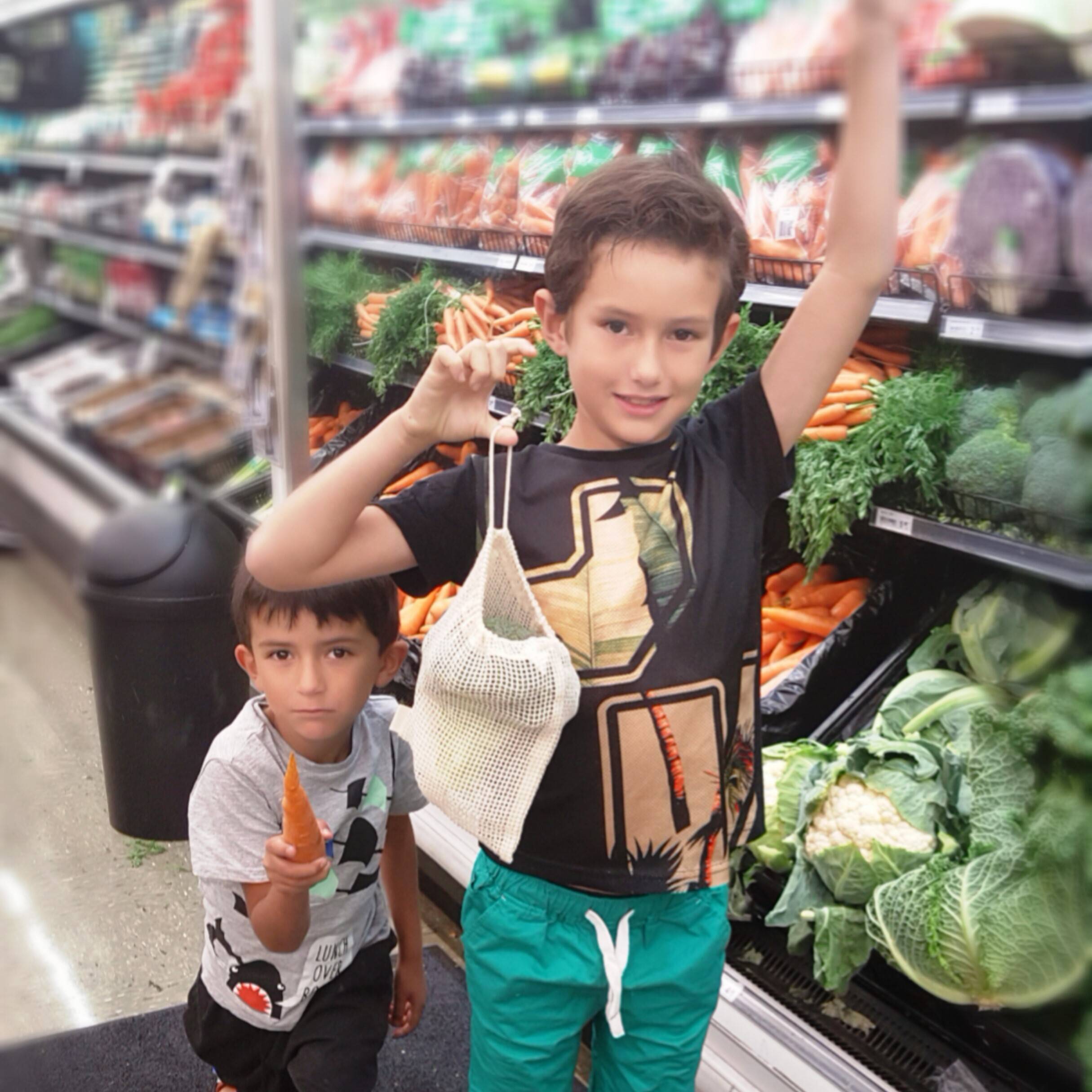 Two boys at the produce department holding My Vita Bag