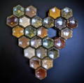 Small hexagonal glass spice jars that are filled with spices are arranged in a heart shaped design