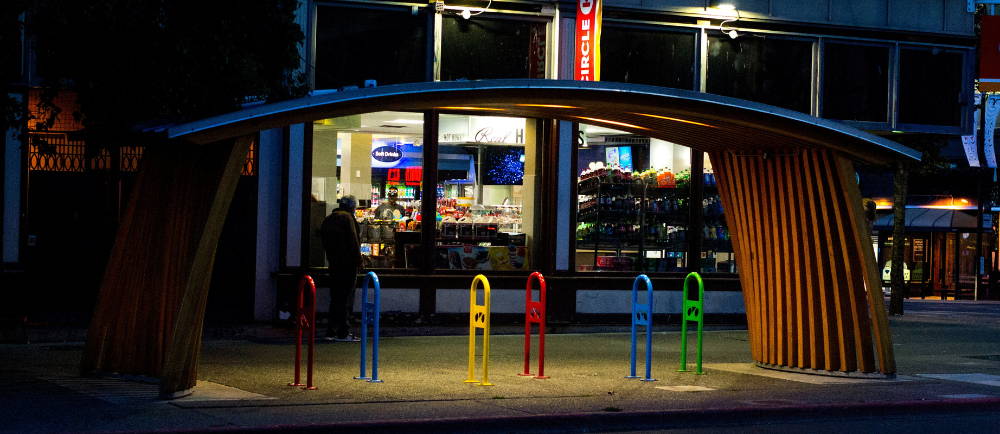 Lit bicycle rack at night in from of store