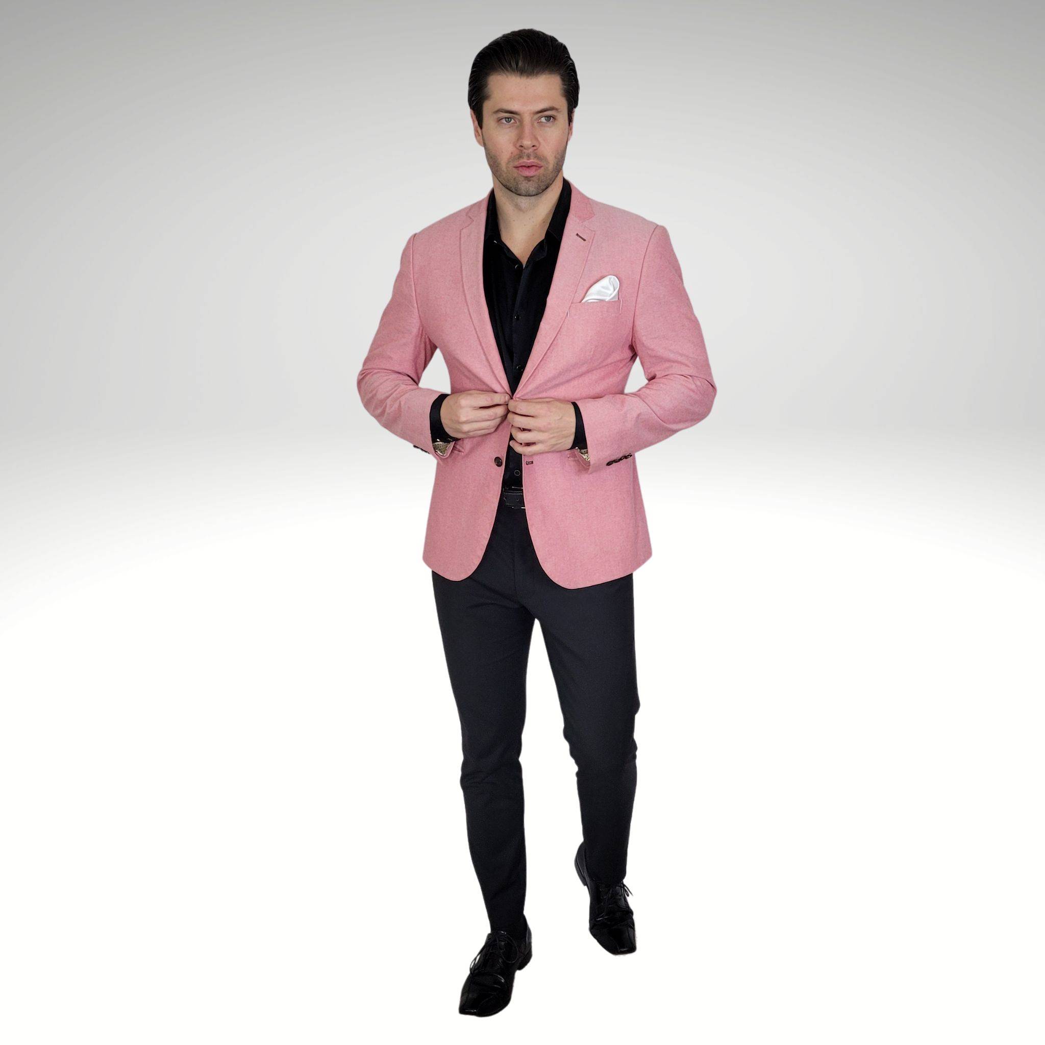 model wearing a black silk shirt underneath a light pink blazer with black pants and black dress shoes