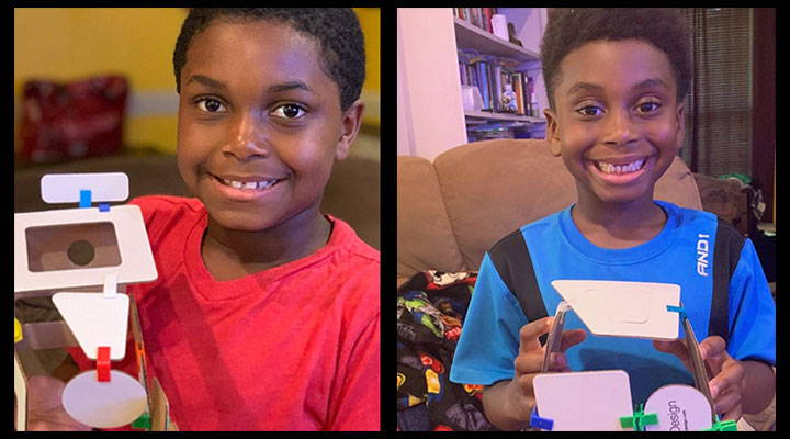 2 boys showing their cardboard model homes