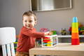 Little boy playing with Montessori Shape Blocks cube in his playroom.