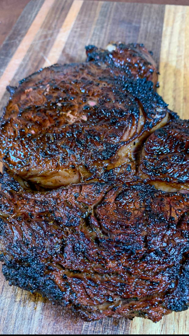 Beef ribeye steak with a beautiful crust from cooking over live fire.  The Maillard Reaction adds incredible flavor and color to a steak