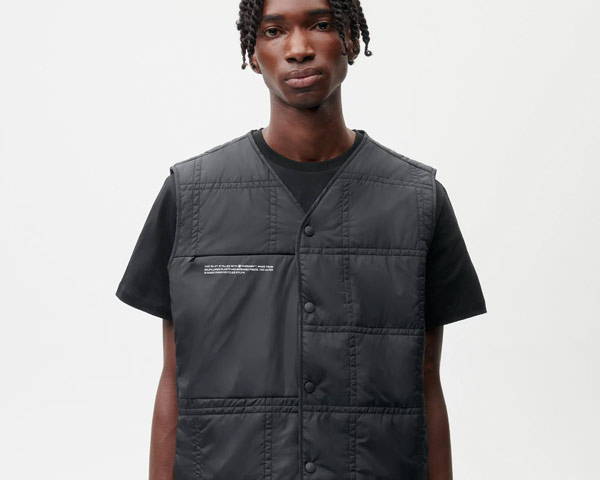 Man wearing black recycled nylon gilet made by London based UK sustainable men's clothing brand Pangaia