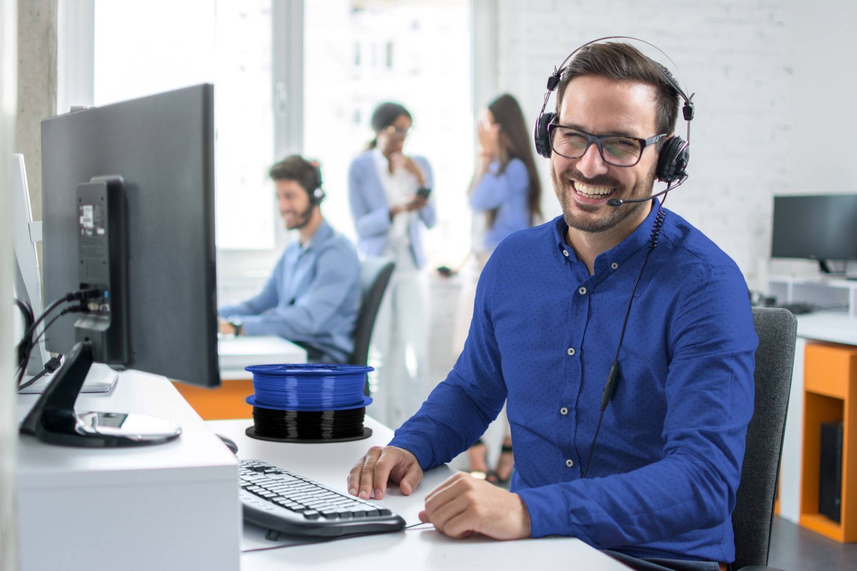 Image of Dremel DigiLab customer service representatives on a call with co-workers in background 