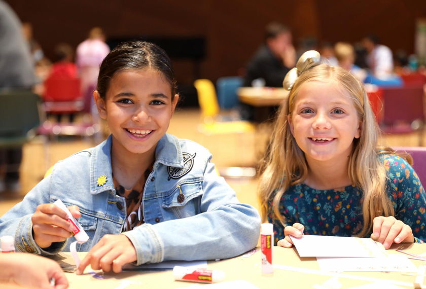 Two smiling children participating in the pre-concert arts workshops