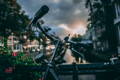 Gros plan sur le guidon d'un vélo devant un canal hollandais au coucher du soleil