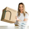 a girl in a t-shirt smiling and holding a box of fresh prepared meals in lethbridge from Nutrimeals.