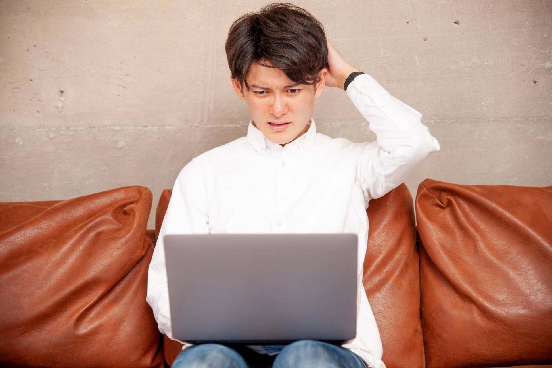 PCを見て困惑する男性