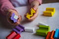 Child holding colorful wooden puzzle blocks. 