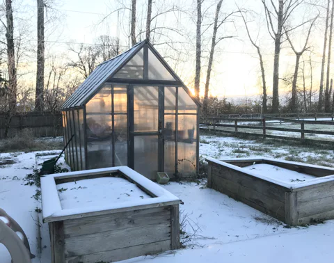 A greenhouse with a light dusting of snow