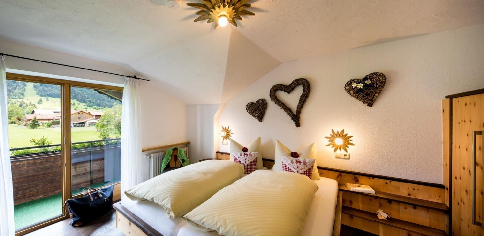 Doppelbett im geräumigen Schlafzimmer der 55m² Wohnung im Allgäu mit Blick auf die Berge