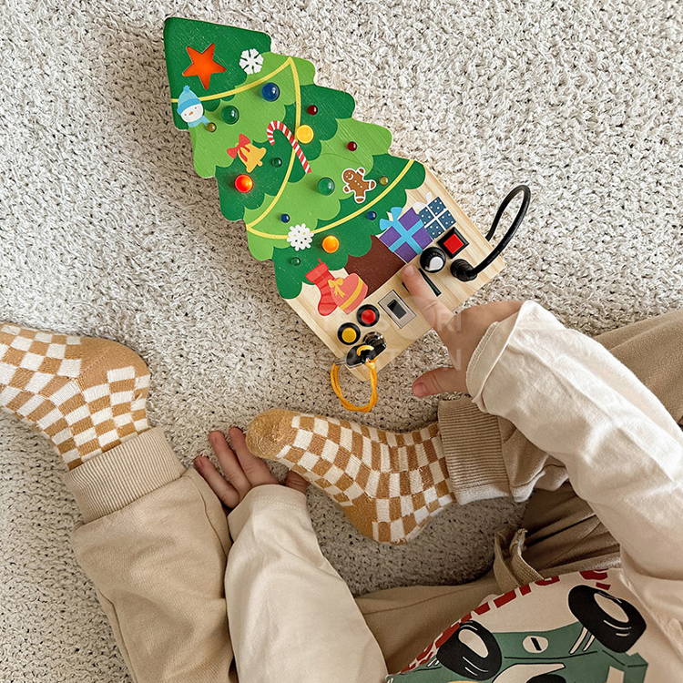 Toddler playing with the interactive Montessori Christmas Switch Board that features lights, toggles, buttons, and switches.