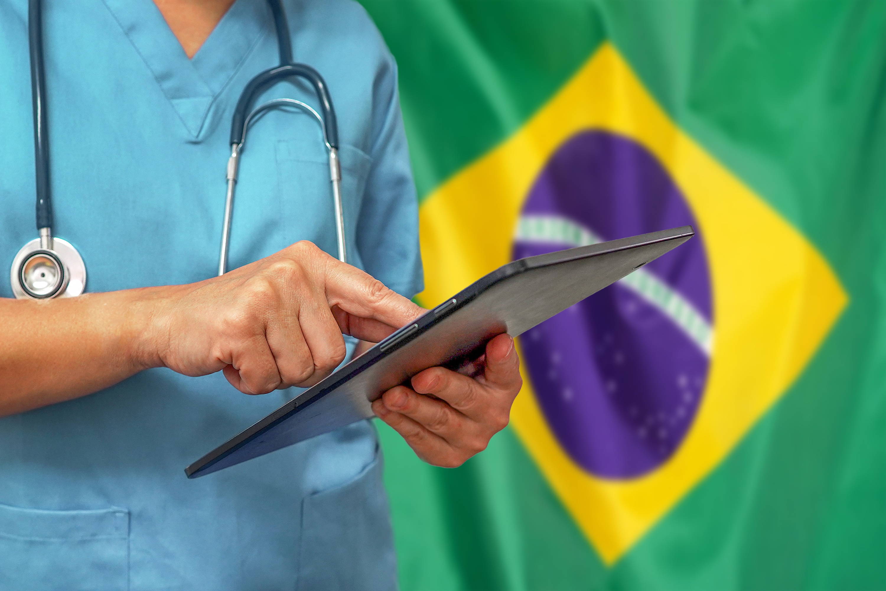 Médico diante de bandeira do Brasil