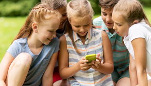 friendship childhood technology people concept group happy kids friends with smartphone summer park