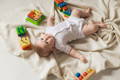 Baby exploring wooden sensory toys during floor play - Montessori toys for newborns 0-3 months