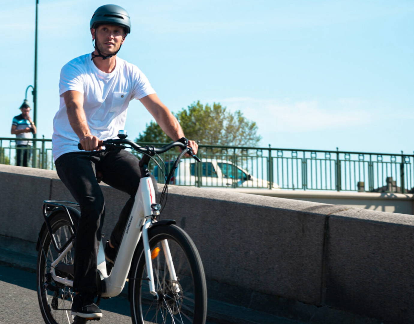 Homme à bord d’un vélo électrique portant un casque de sécurité et possédant les accessoires indispensables pour une conduite sécurisée