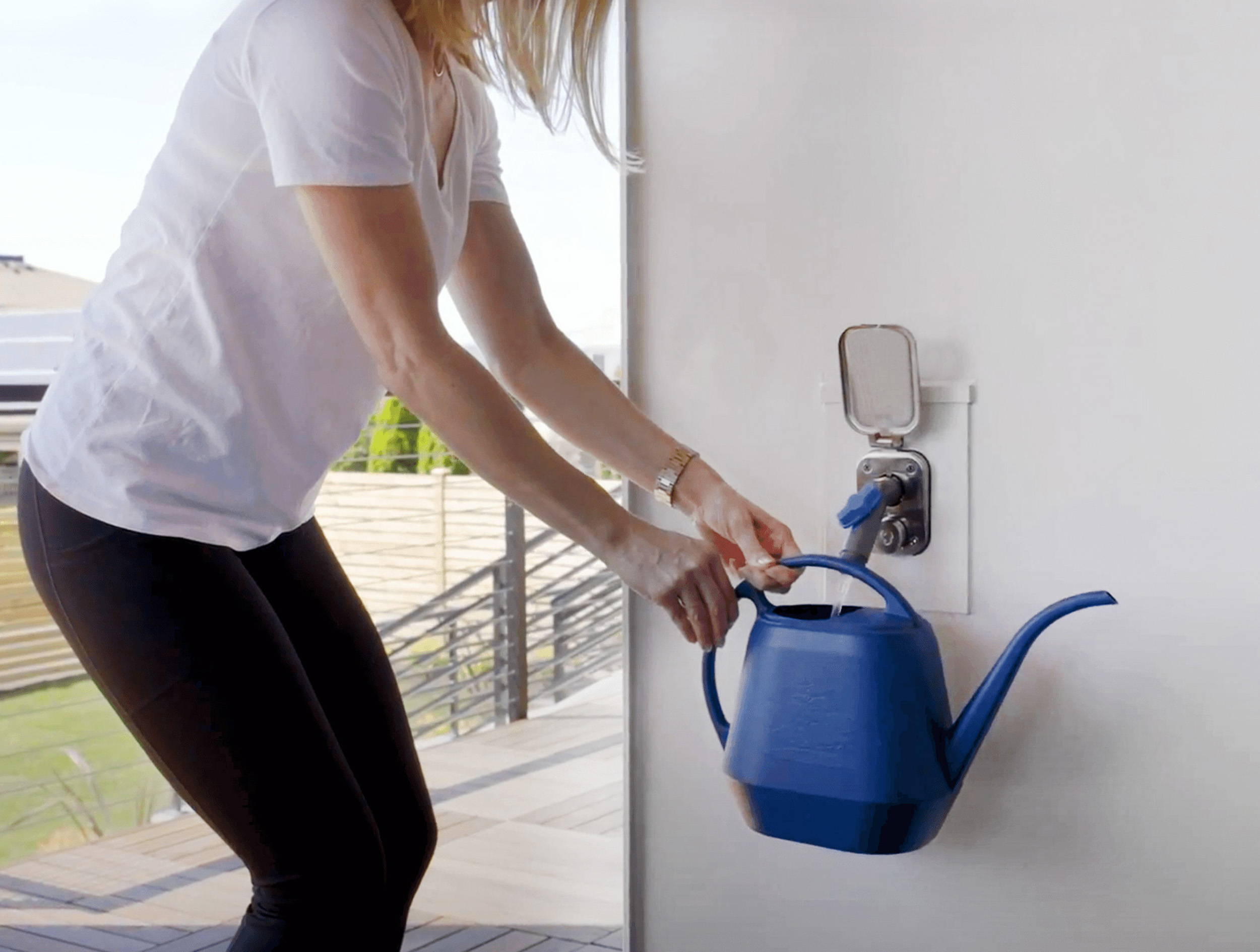 Woman filling up watering can with Aquor House Hydrant V2+ and Removable Faucet Connector