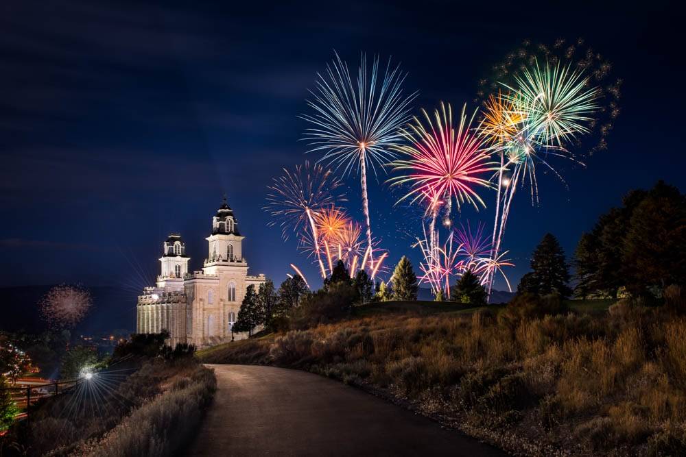 Photo of the Manti Temple against a night sky full of fireworks. 