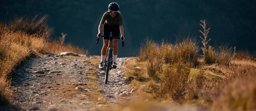 a woman riding a La Pierre electric road bike on a gravel road