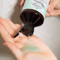Davines Naturaltech DETOXIFYING Shampoo being poured into a hand