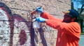 Man removing graffiti from brick