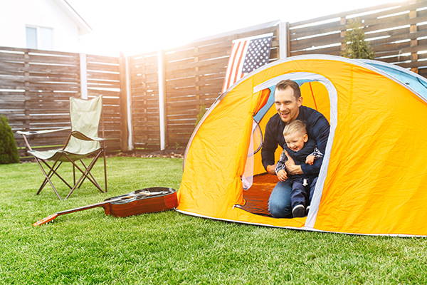 Father and toddler backyard camping